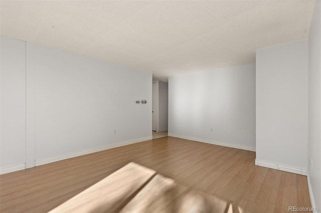 unfurnished room featuring a textured ceiling and light wood-type flooring