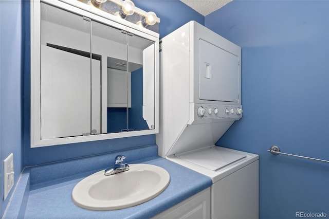 bathroom featuring stacked washer / drying machine and sink