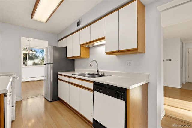 kitchen with sink, baseboard heating, white cabinetry, white dishwasher, and light wood-type flooring