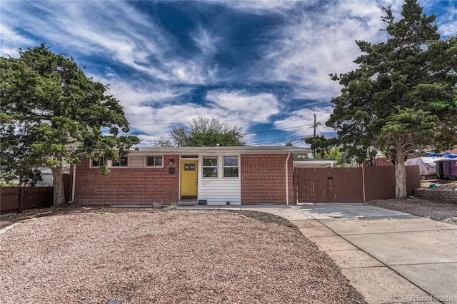 1906 S Vrain St, Denver, CO 80219 - ranch-style house with brick siding, fence, driveway, and a gate