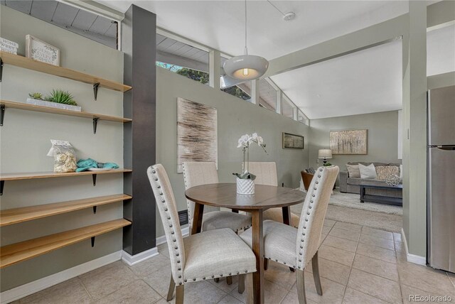 1906 S Vrain St, Denver, CO 80219 - dining space with healthy amount of natural light, baseboards, light tile patterned floors, and vaulted ceiling
