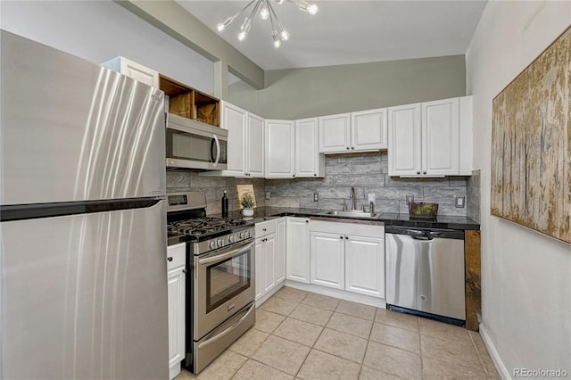 1906 S Vrain St, Denver, CO 80219 - kitchen featuring stainless steel appliances, a sink, tasteful backsplash, dark countertops, and lofted ceiling