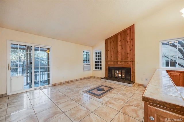 living room with plenty of natural light, a large fireplace, lofted ceiling, and cooling unit