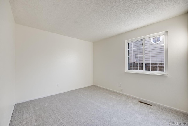 empty room featuring a textured ceiling and carpet