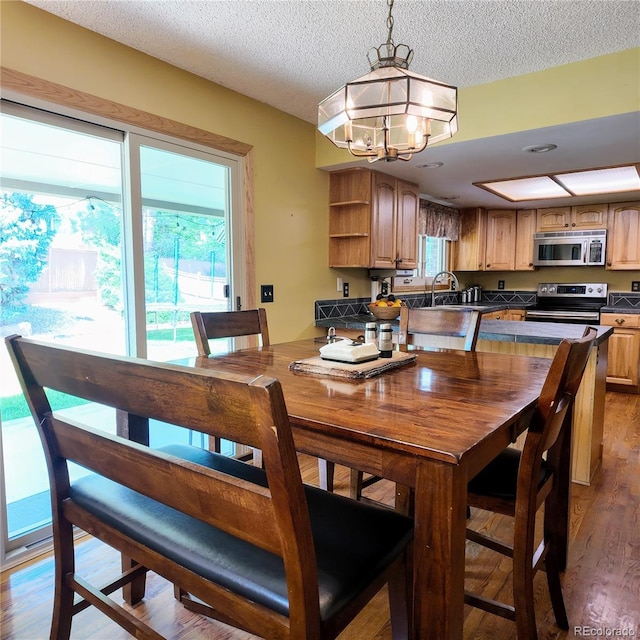 16639 E Berry Ln, Centennial, CO 80015 - dining area with a chandelier, wood finished floors, and a textured ceiling
