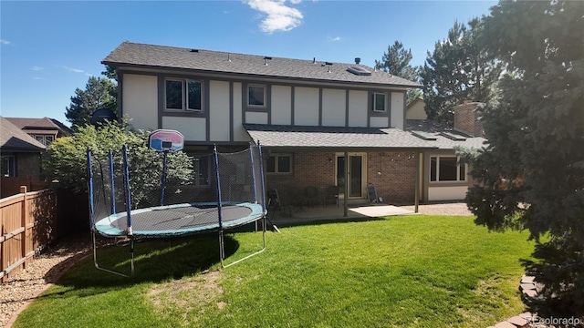 16639 E Berry Ln, Centennial, CO 80015 - back of house featuring a trampoline, a shingled roof, a patio area, and brick siding