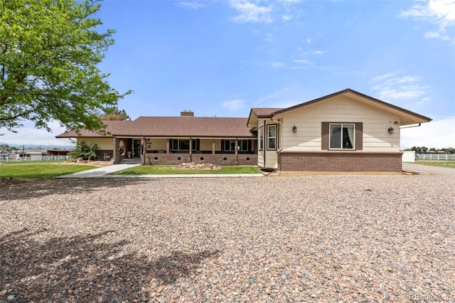 1851 E 138th Ave, Brighton, CO 80602 - rear view of house with brick siding, a chimney, and a porch