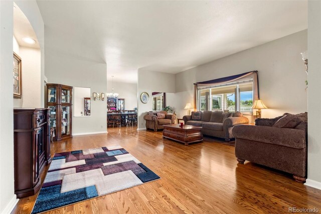 1851 E 138th Ave, Brighton, CO 80602 - living area with wood finished floors, a chandelier, baseboards, and arched walkways