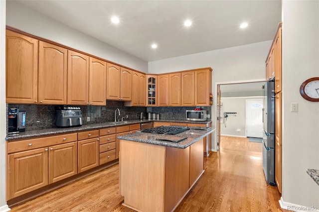 1851 E 138th Ave, Brighton, CO 80602 - kitchen featuring appliances with stainless steel finishes, tasteful backsplash, a center island, a sink, and light wood-style flooring
