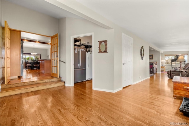 1851 E 138th Ave, Brighton, CO 80602 - corridor with plenty of natural light, light wood-type flooring, and a chandelier