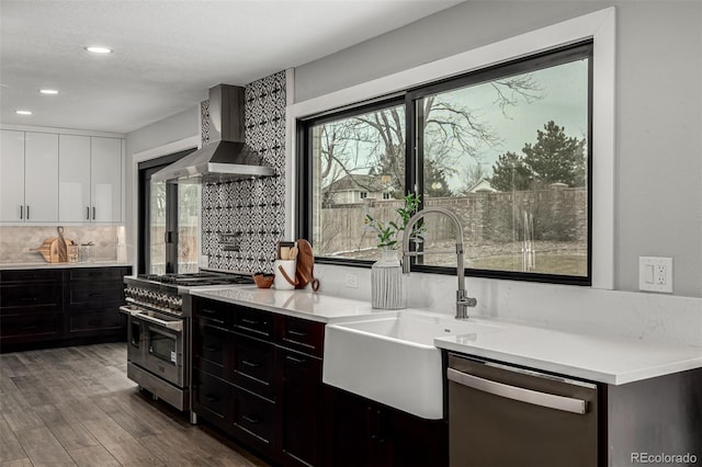 11861 E Yale Ct, Aurora, CO 80014 - kitchen featuring wall chimney range hood, appliances with stainless steel finishes, plenty of natural light, tasteful backsplash, and recessed lighting