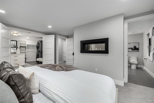 11861 E Yale Ct, Aurora, CO 80014 - carpeted bedroom featuring stacked washer / drying machine, recessed lighting, a spacious closet, ensuite bath, and a closet