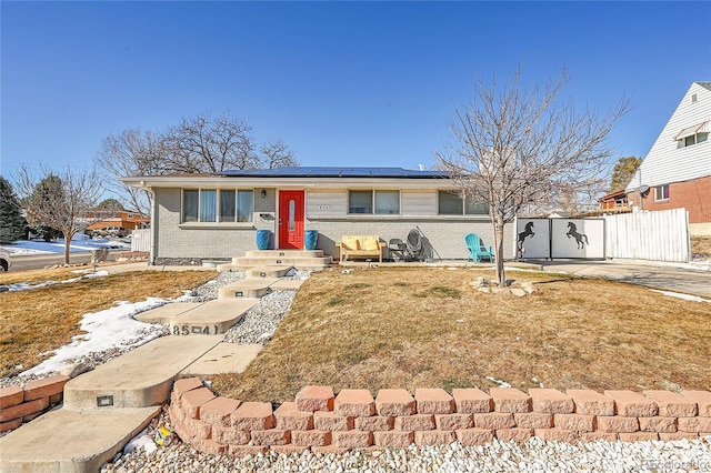 single story home with a front lawn and solar panels