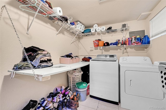 washroom with washer and clothes dryer and light tile patterned floors