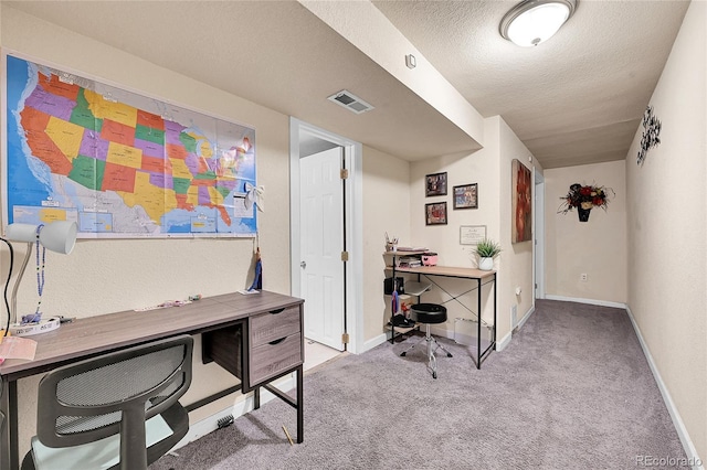 carpeted office space featuring a textured ceiling