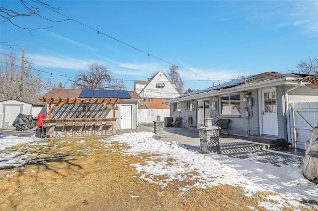 view of front of property with a storage unit, a patio area, central air condition unit, and solar panels