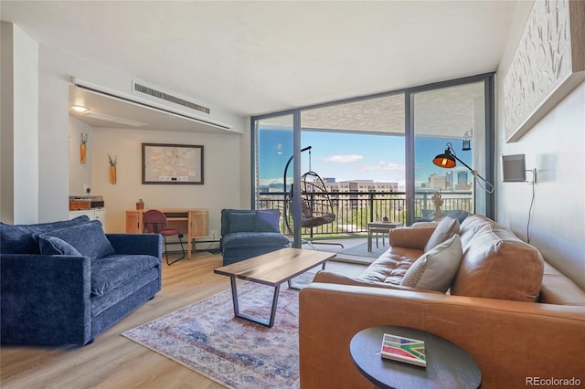 550 E 12th Ave Unit 810, Denver, CO 80203 - living room with wood finished floors, expansive windows, and a baseboard heating unit