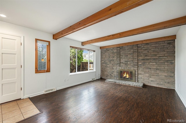 1233 S Yosemite Way Unit 74, Denver, CO 80247 - unfurnished living room featuring wood finished floors, a fireplace, beam ceiling, and recessed lighting