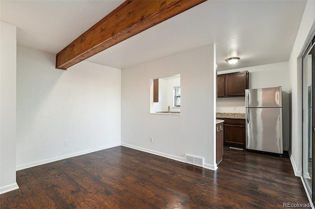 1233 S Yosemite Way Unit 74, Denver, CO 80247 - unfurnished living room with dark wood-type flooring and beamed ceiling