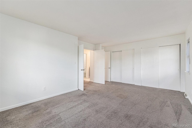 1233 S Yosemite Way Unit 74, Denver, CO 80247 - unfurnished bedroom featuring two closets and carpet