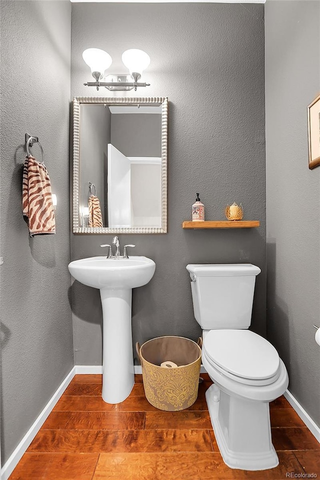 bathroom with sink, wood-type flooring, and toilet