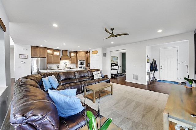 living room featuring ceiling fan, dark wood finished floors, visible vents, and recessed lighting