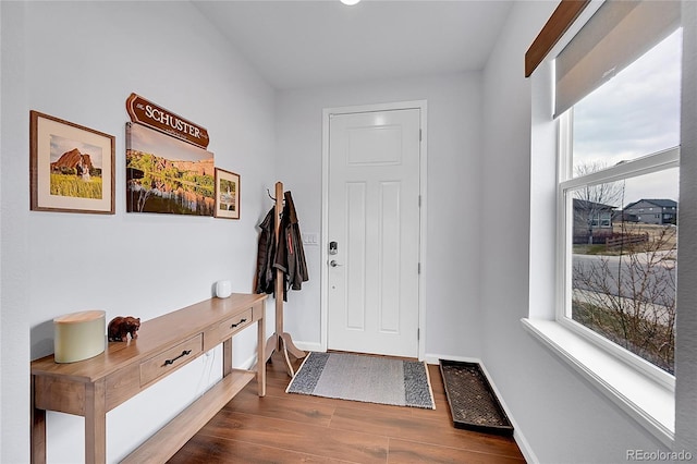 doorway with visible vents, baseboards, and dark wood-style flooring