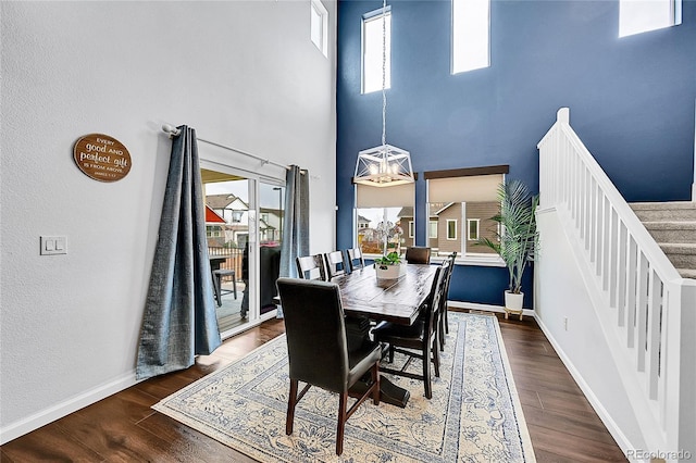 dining area with stairway, baseboards, and wood finished floors