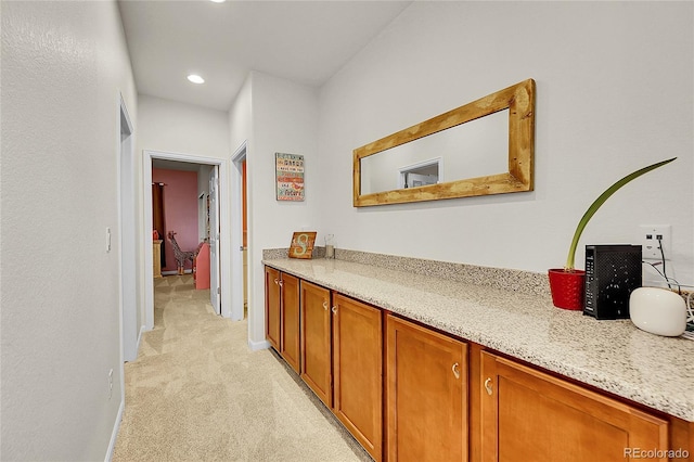 hall featuring light colored carpet and baseboards