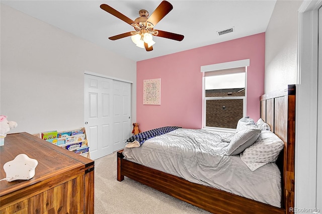 carpeted bedroom with a ceiling fan, visible vents, and a closet