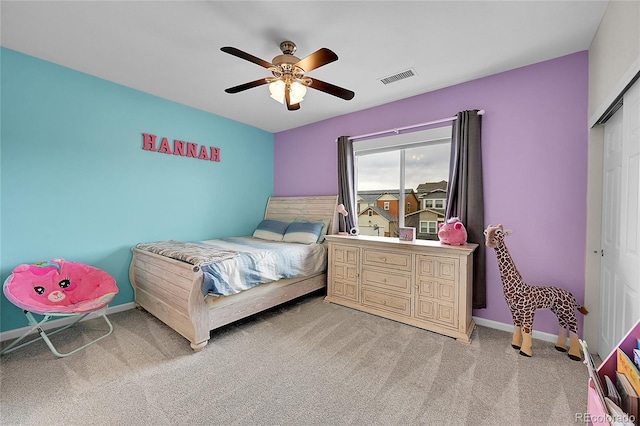 bedroom featuring a closet, visible vents, a ceiling fan, light carpet, and baseboards