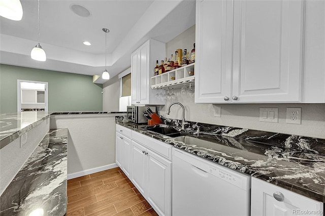 kitchen featuring wood finish floors, white cabinets, white dishwasher, and decorative light fixtures