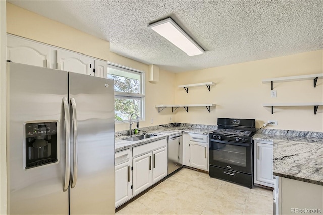 kitchen with white cabinets, sink, stone countertops, a textured ceiling, and stainless steel appliances