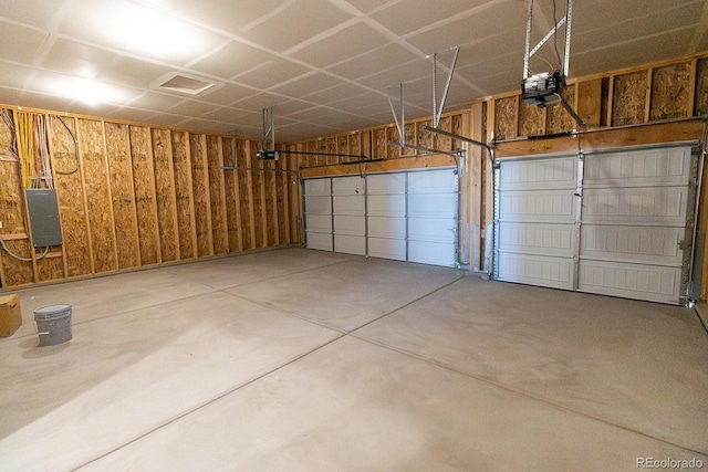 garage with electric panel, wood walls, and a garage door opener