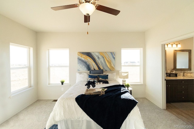 carpeted bedroom with ceiling fan, sink, and connected bathroom