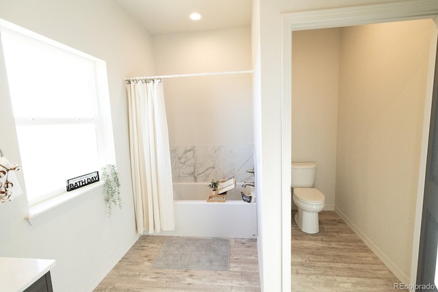 bathroom featuring hardwood / wood-style floors, vanity, toilet, plenty of natural light, and a tub