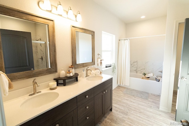 bathroom with vanity, wood-type flooring, and shower with separate bathtub