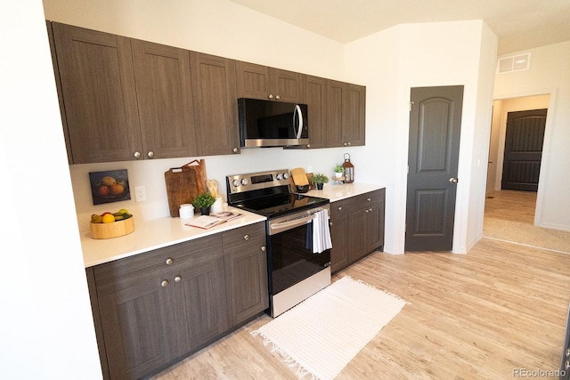 kitchen with appliances with stainless steel finishes, light wood-type flooring, and dark brown cabinets