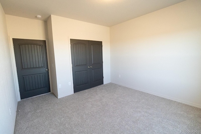 unfurnished bedroom featuring light colored carpet and a closet