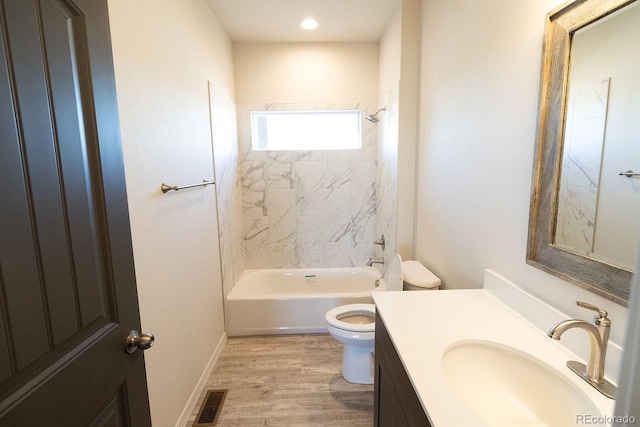 full bathroom featuring wood-type flooring, vanity, toilet, and tiled shower / bath combo