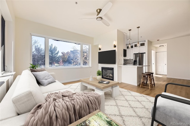 living room with ceiling fan and light hardwood / wood-style floors