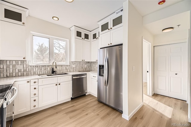 kitchen featuring sink, white cabinets, stainless steel appliances, and light hardwood / wood-style floors