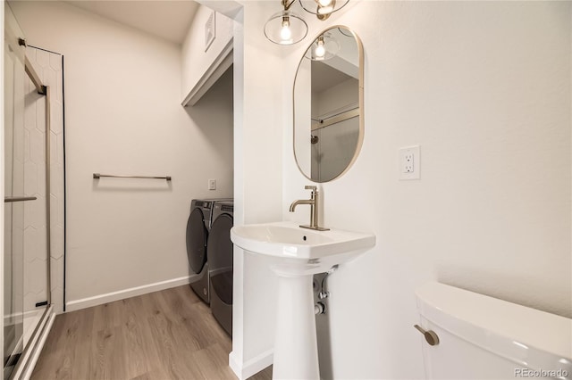 bathroom featuring a shower, washer and clothes dryer, hardwood / wood-style floors, and toilet