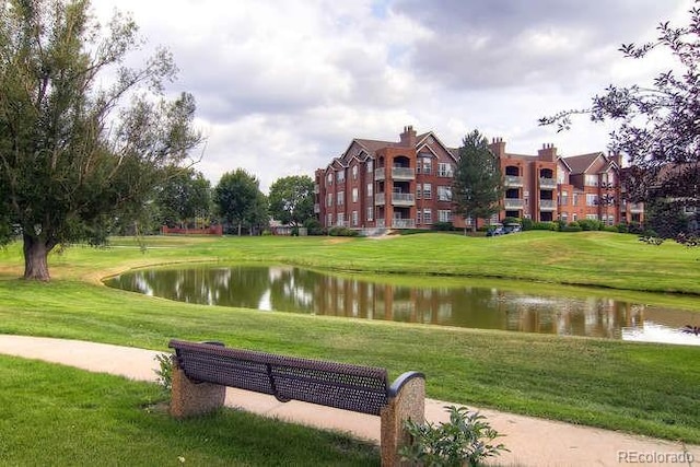 view of property's community featuring a lawn and a water view