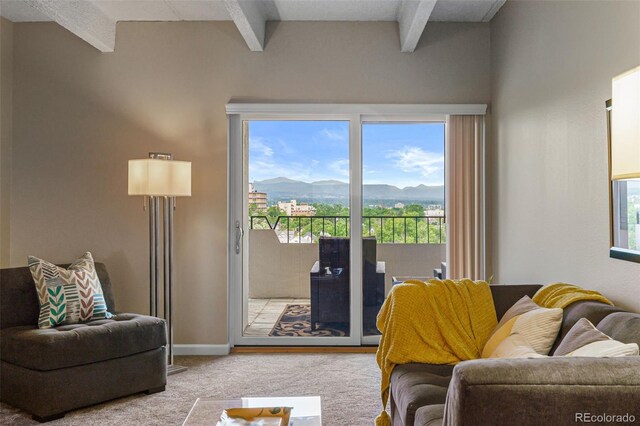 living room with baseboards, a mountain view, beamed ceiling, and light colored carpet