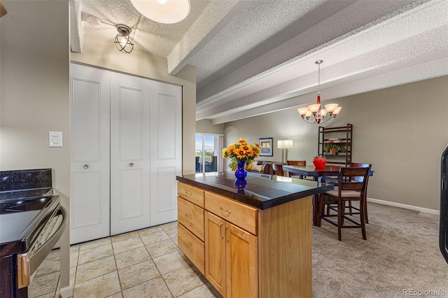 kitchen with a center island, a notable chandelier, dark countertops, a textured ceiling, and beamed ceiling