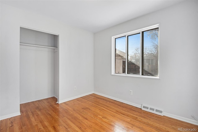 unfurnished bedroom featuring a closet and light hardwood / wood-style flooring