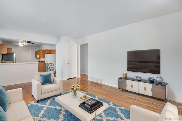 living room featuring ceiling fan and light wood-type flooring