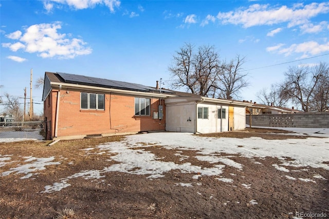 snow covered property with solar panels