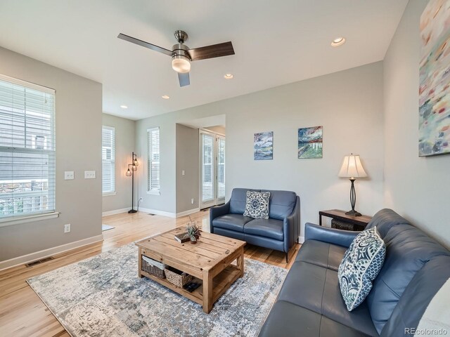 living room featuring ceiling fan and light hardwood / wood-style flooring